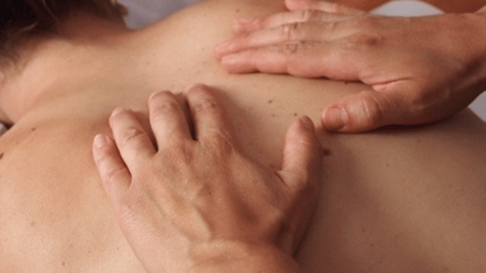 massage therapist massaging client's back