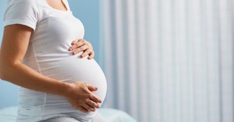 pregnant woman cradling belly