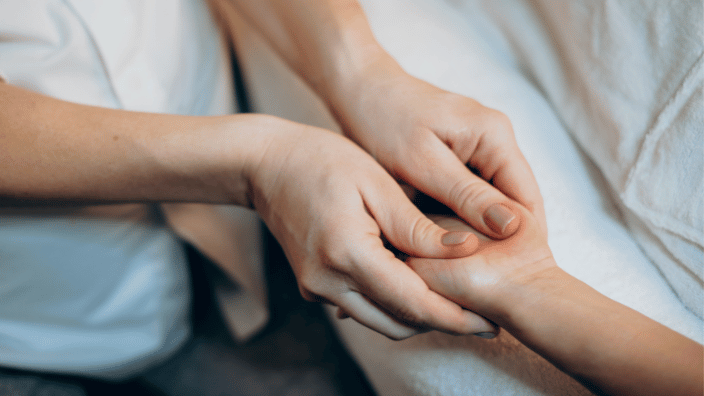 massage therapist massaging a client's hand