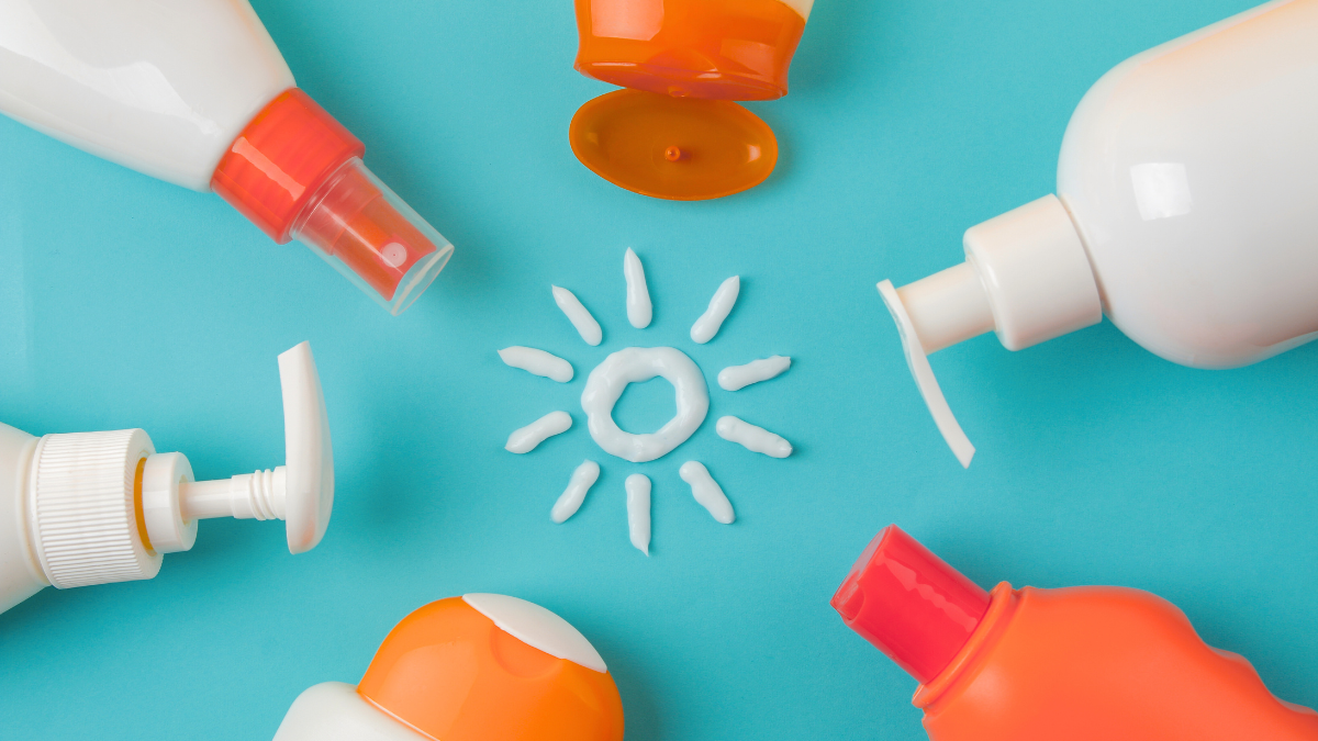 An image of six sunscreen bottles arranged in a circle with their caps towards the middle where sunscreen lotion is arranged to form a sun.